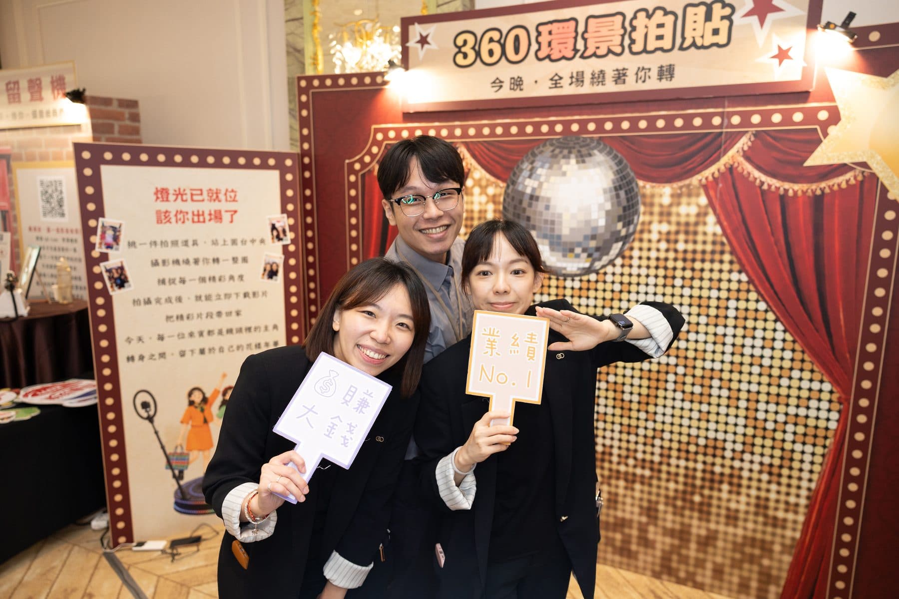 三位賓客在 360 環景拍貼區前手持發光手舉牌合影，背景為復古戲院風格背板