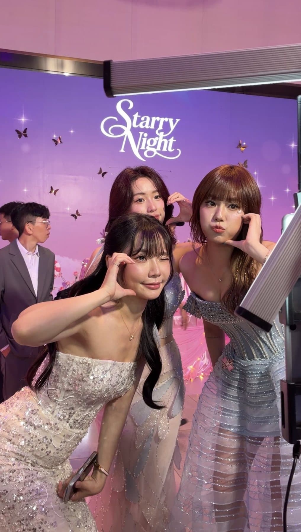 浪LIVE 星潮之夜 Starry Night 主視覺背板前，三位賓客拿著簽名相片卡合影
