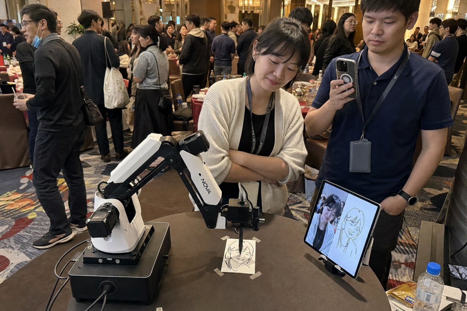 AI 素描機器人在企業活動迎賓區作畫，賓客彎身看代針筆一筆一筆畫出自己的人像