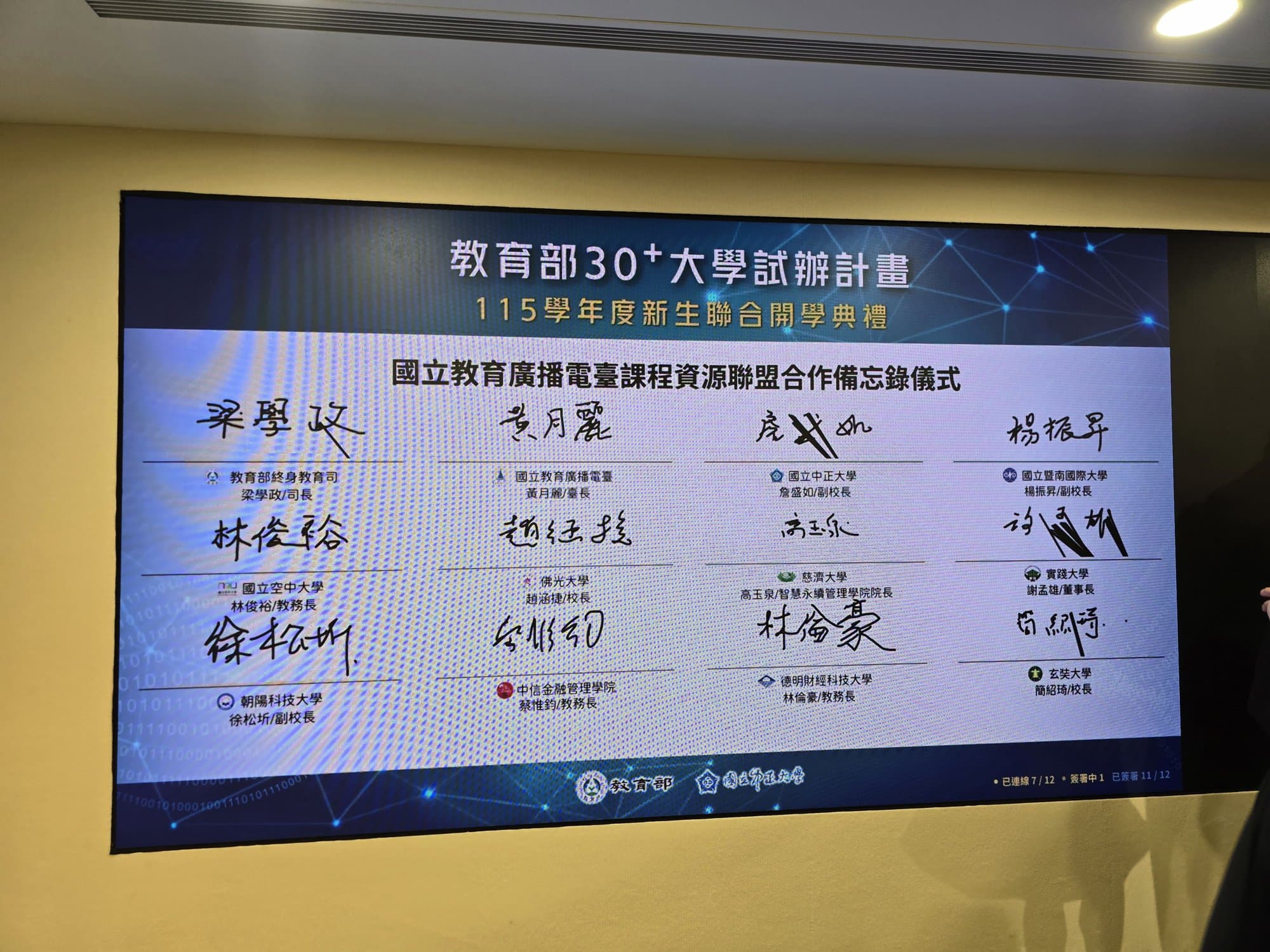 大螢幕特寫：12 位貴賓的簽名與姓名職稱全部完成