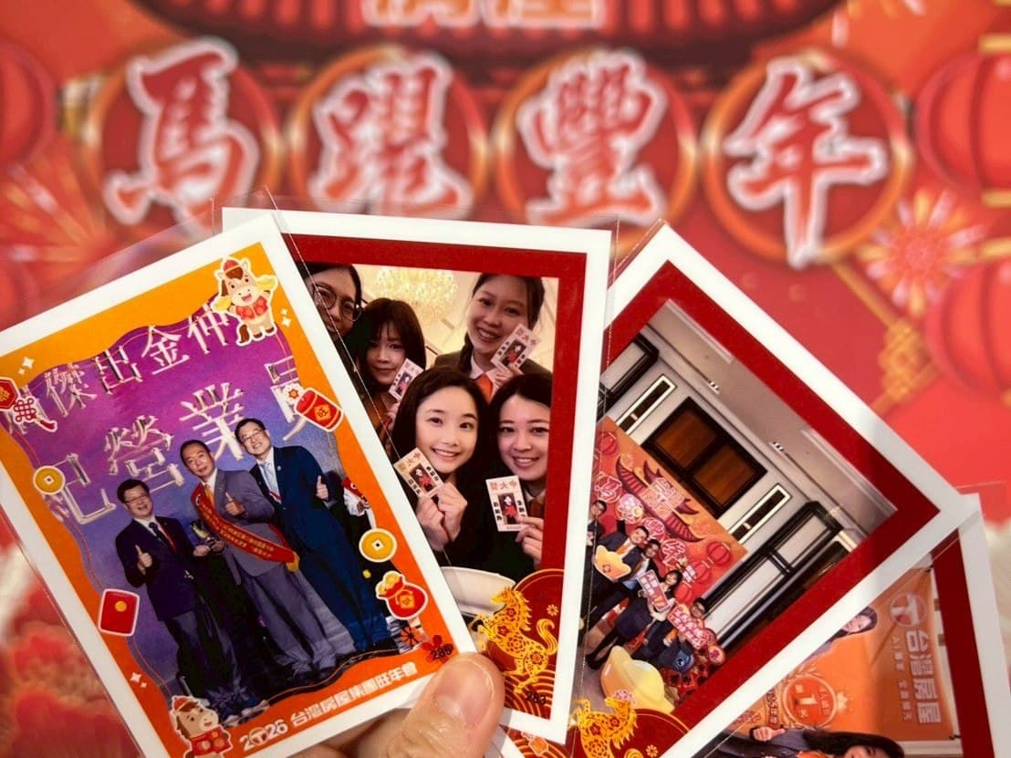 赤い新年会の背景ボードの前で、同じカスタムフレームの写真5枚を手に広げている