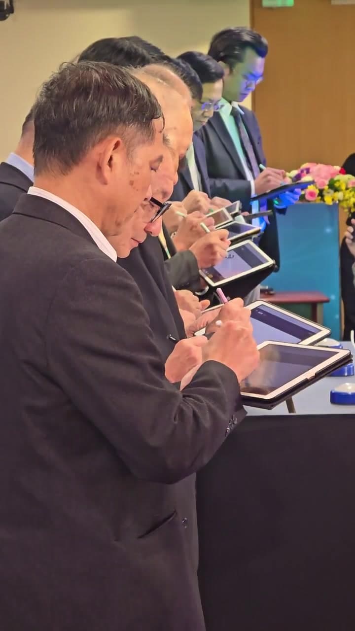 側面近拍:貴賓手持 iPad,以觸控筆在簽名區書寫